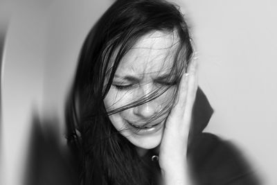 Close-up sad woman against white background