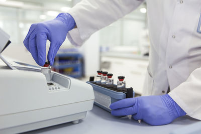 Midsection of scientist working at desk in laboratory