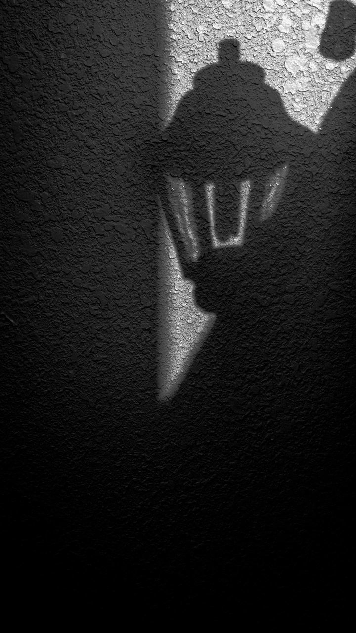 SHADOW OF MAN ON WALL