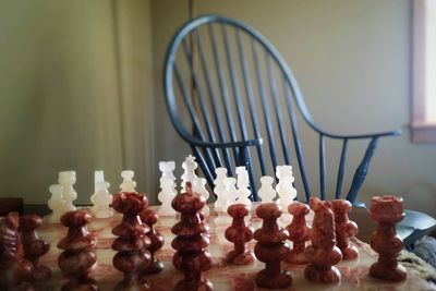 Arranged chess board on table next to chair