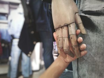 Cropped hand of person holding mannequin