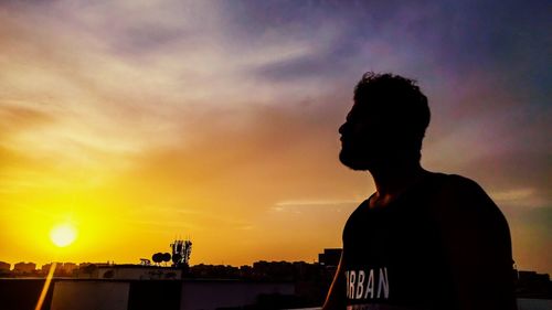 Silhouette man standing against sky during sunset