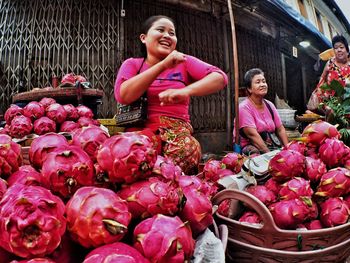 Woman with pink flowers in basket at market