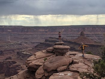 Rock formations on landscape against cloudy sky