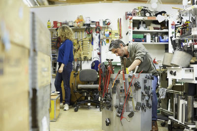 Mature male volunteer working by tools in workshop