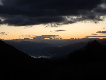 Scenic view of silhouette mountains against sky during sunset