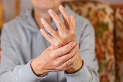Senior woman suffering from hand and finger joint pain and inflammation. rheumatoid arthritis, gout