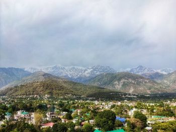 Aerial view of buildings and mountains against sky