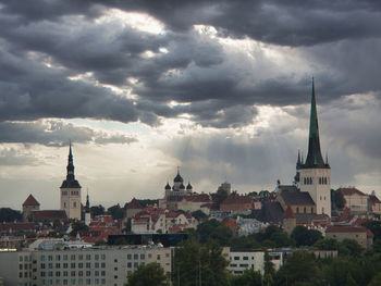 Buildings in city against cloudy sky