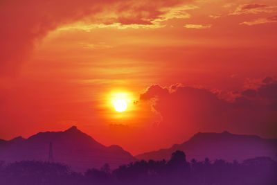 Scenic view of silhouette mountains against romantic sky at sunset