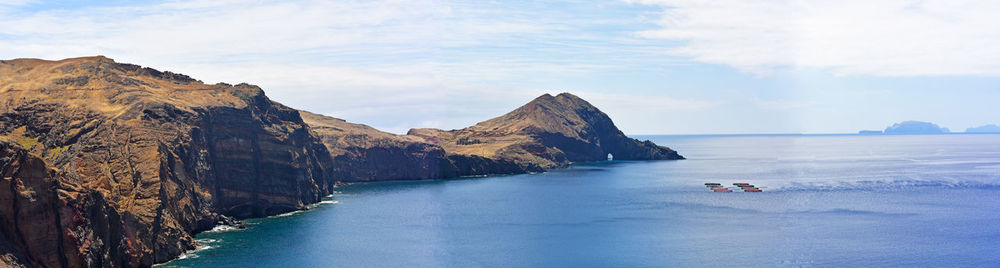 Scenic view of sea and mountains against sky