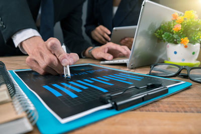 Midsection of man using laptop on table