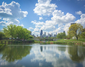 Reflection of trees in lake against cloudy sky chicago skyline