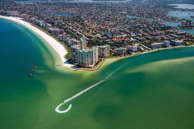 Aerial view of wake in sea by cityscape