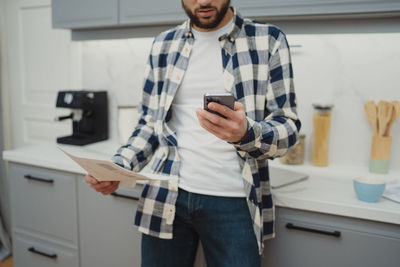 Young man standing against wall
