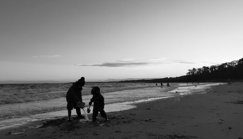 People on beach against sky