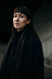 Portrait of beautiful woman standing against wall