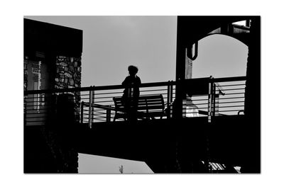 Silhouette man walking on staircase against building