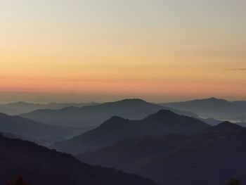 Scenic view of silhouette mountains against sky during sunrise 