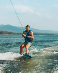 Full length of wakeboarding in sea