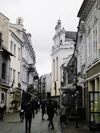 People walking on road along buildings