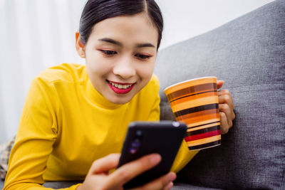 Portrait of smiling man using mobile phone