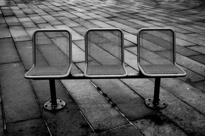 High angle view of empty chairs on footpath