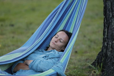 Portrait of woman lying on hammock
