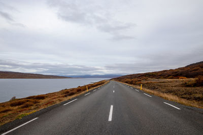 Road amidst green landscape against sky