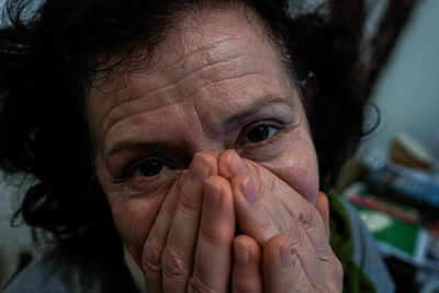 Close-up portrait of woman with hands covering mouth