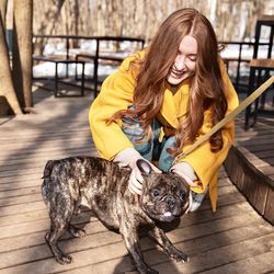 Happy woman with dog on walkway