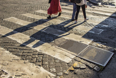 Low section of woman walking on footpath