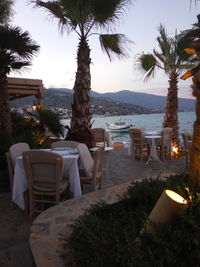 Chairs and table at beach against sky