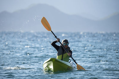 One woman paddling on a seat on top kayak close to the shore of carmen island in loreto, baja california, mexico.