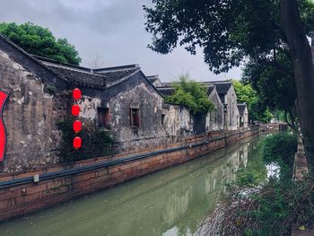 View of canal by building against sky