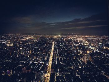 High angle view of illuminated city against sky at night