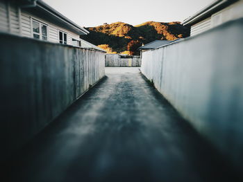 Road amidst buildings in town against sky