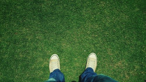 Low section of man standing on grassy field