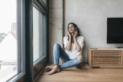 Relaxed woman listening to music at home