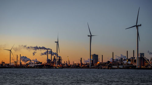 Pollution by tata steel. sunset with reflection in the sky. smoke from the chimneys  windmills