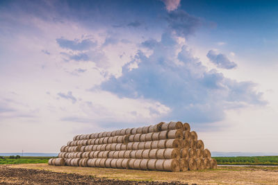 Hay bales on field against sky