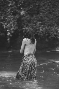Rear view of woman standing in water