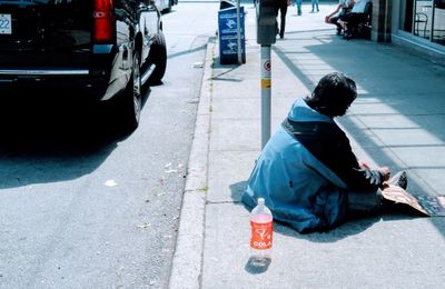 Rear view of a woman sitting on road