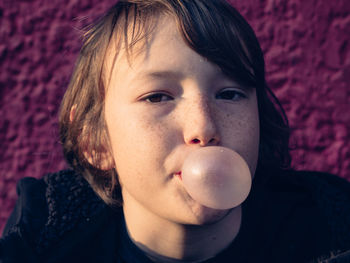 Close-up of boy blowing chewing gum