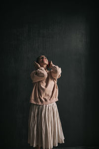 Portrait of woman wearing hat against wall