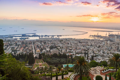 High angle view of townscape by sea against sky during sunset