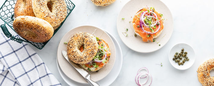 Narrow view of everything bagels with cream cheese, smoked salmon lox, topped with capers.