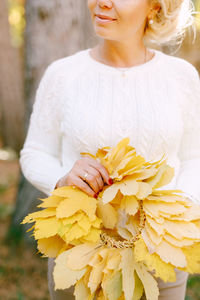 Midsection of woman holding flower bouquet