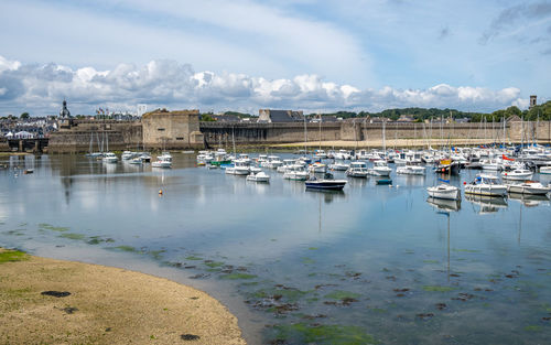 Boats moored in harbor against sky