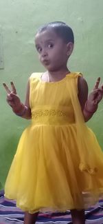 Cute boy looking away while standing against wall